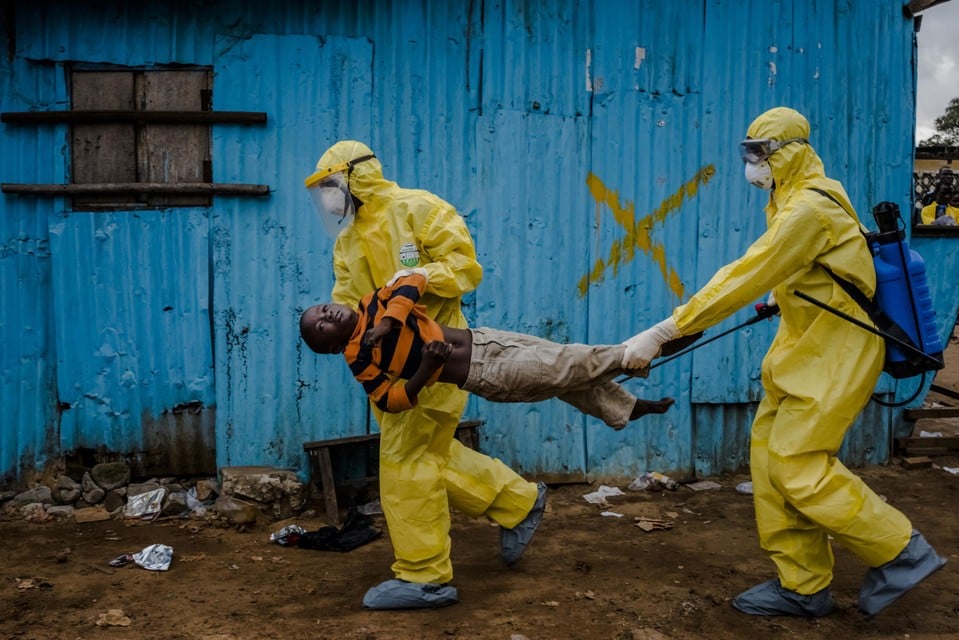 Hulpverleners tijdens een uitbraak van ebola in 2014, in Liberië.