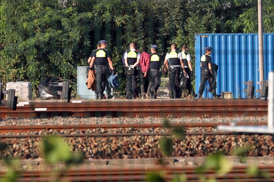 Agenten voeren transmigranten af na een actie in Antwerpen. 