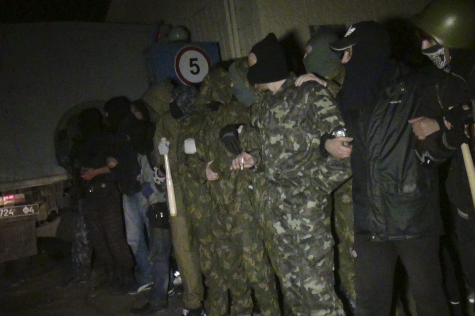 Pro-Russische activisten staan nabij de militaire basis in Mariupol.