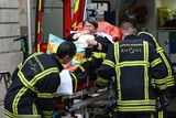 thumbnail: Een vrouw wordt door ambulanciers naar het ziekenhuis gebracht na een ontploffing in Lyon