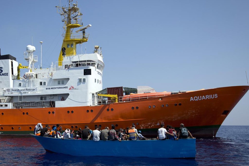 Het ngo-schip Aquarius pikt een houten bootje met vluchtelingen op in de Middellandse Zee. 