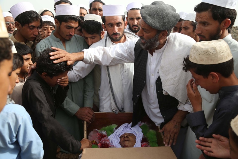 Afghanen nemen afscheid van de slachtoffers van een zelfmoordaanval, vermoedelijk uitgevoerd door Taliban-strijders. 