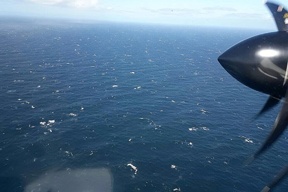 Een vliegtuig speurt de zee af op zoek naar de duikboot. 