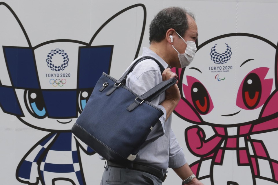 Een Japanse man passeert de Olympische mascottes. 