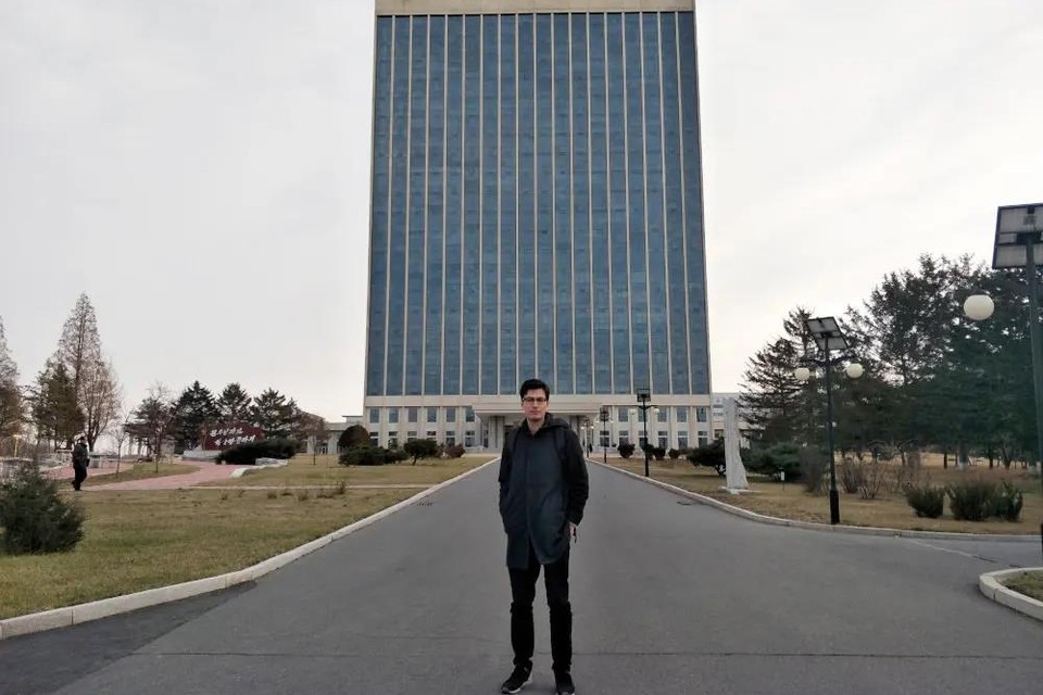 Alek Sigley voor een gebouw van de Kim Il Sung University in Pyongyang. 