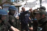 thumbnail: Agenten houden pro-migratie-activisten tegen. 