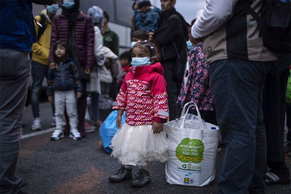 Vluchtelingen en migranten wachten op de bus nadat ze zijn aangekomen in Piraeus, de haven van Athene. Ze komen van Moria, een kamp op het eiland Lesbos. 