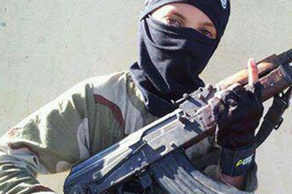 Een kindsoldaat poseert met een wapen in Raqqa, Syrië. 