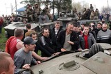 thumbnail: WOENSDAG. In het oosten van Oekraïne houden pro-Russische activisten en Oekraïnse militairen een krachtmeting. Burgers blokkeren Oekraïense soldaten en gewapende mannen bemannen pantservoertuigen met een Russische vlag.