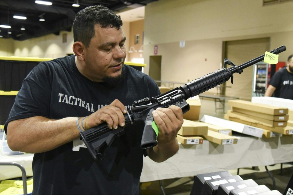 Een verkoper toont een van zijn geweren op de jaarlijkse wapenbeurs in Florida, die enkele dagen na de schietpartij plaatsvond. 