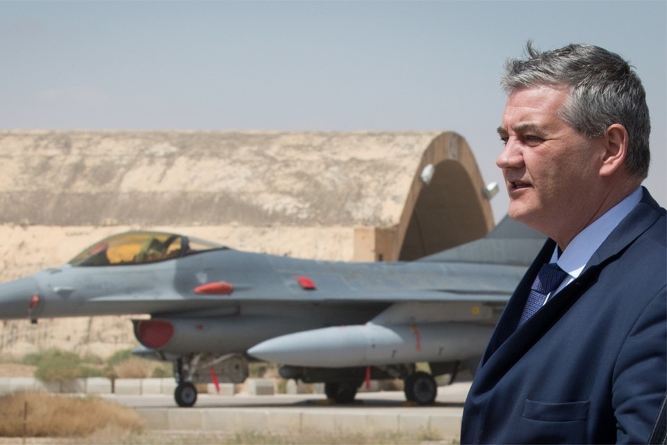 Minister Steven Vandeput, met in de achtergrond een te vervangen F-16. 
