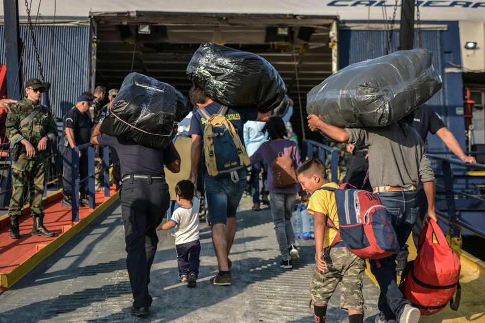 Migranten stappen aan boord van een ferry naar het Griekse vasteland. 