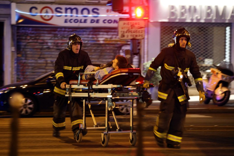 De hulpdiensten brengen een slachtoffer van de aanslagen in Parijs in veiligheid (2015)