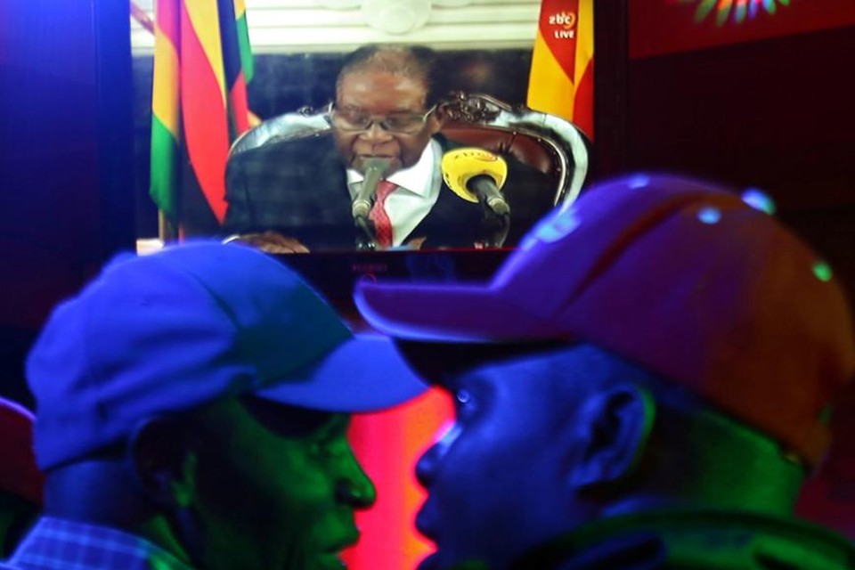 Zimbabwanen volgen de speech van Mugabe op televisie.