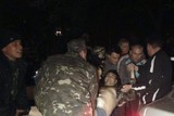 thumbnail: Mensen dragen een man die gewond is geraakt nabij de militaire basis in Mariupol.