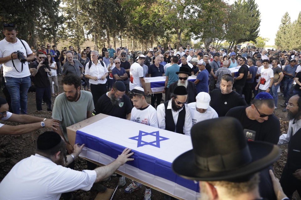 Israëliërs begraven slachtoffers van de raids die Hamas uitvoerde.
