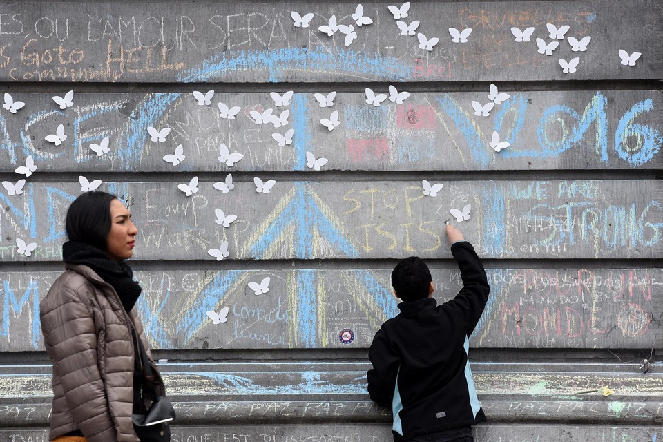 Maart 2016. Een jongen schrijft ‘Stop IS’ op een muur als protest tegen de aanslagen in Brussel. © Patrick Stollarz/afp