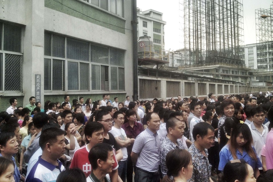 Werknemers van de Yue Yuen-fabriek verzamelden buiten aan de gebouwen van de fabriek.