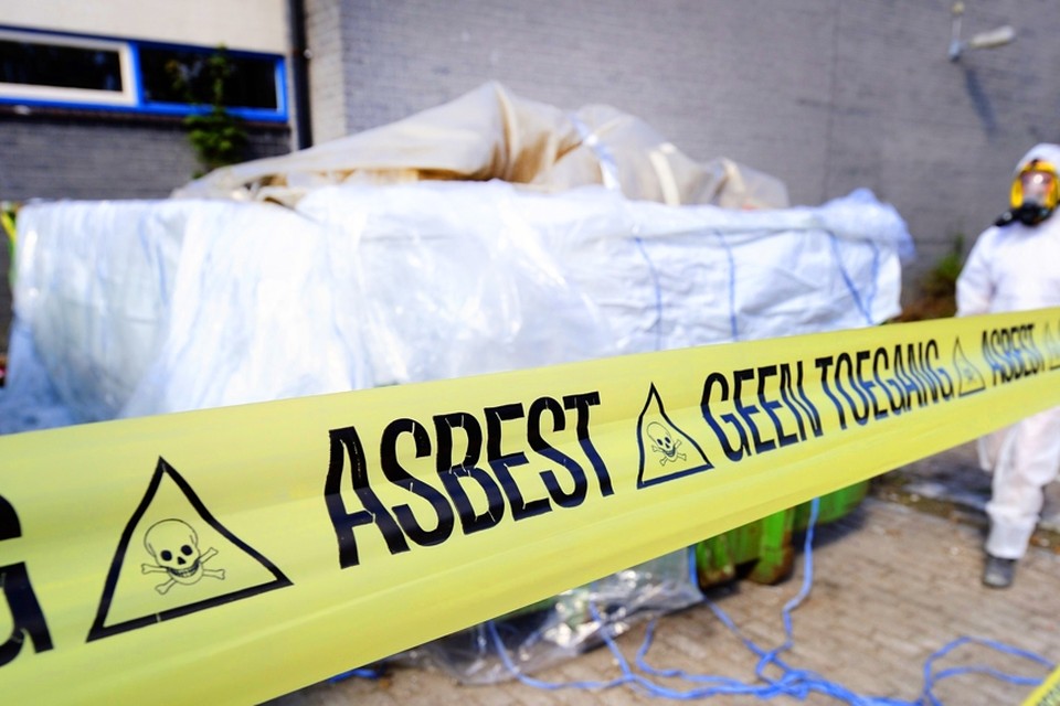 Een medewerker van een asbestsaneringsbedrijf verwijders asbest (archiefbeeld) 