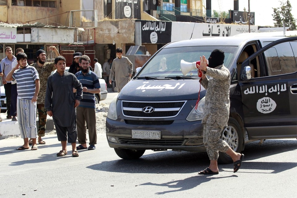 Een IS-militant spreekt de plaatselijke bevolking toe in Tabqa (2014). 