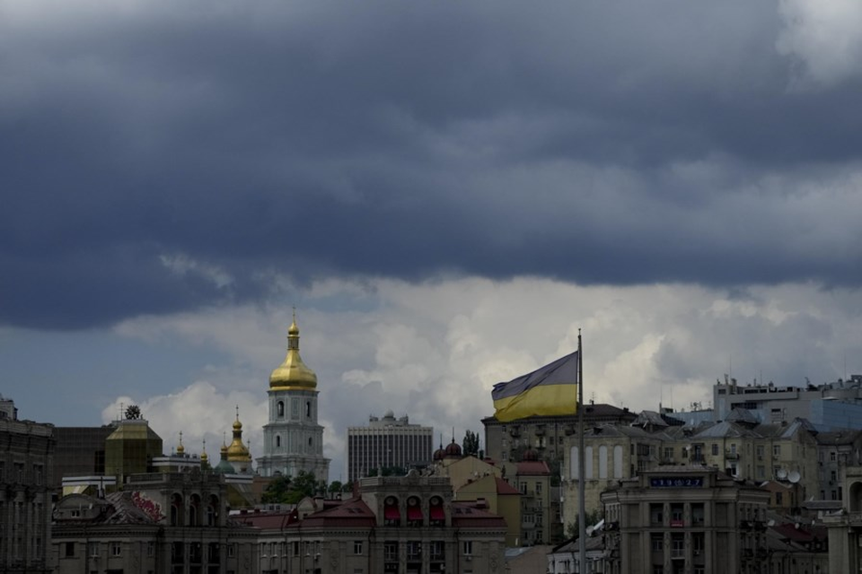 Een Oekraïense vlag en donkere wolken boven Kiev.  