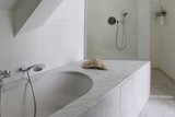 thumbnail: De badkamer werd afgewerkt in statig wit marmer.