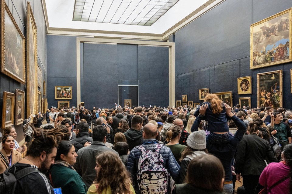 De Mona Lisa en de massa die het schilderij probeert te bekijken.